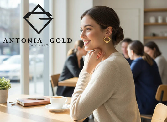 Femeie purtând cercei Antonia Gold în formă de inimă din aur galben lucios, într-o cafenea luminoasă.