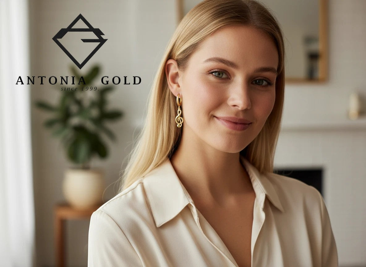 Femeie purtând cercei Antonia Gold tip verigă din aur galben cu pandantiv în formă de cheia sol, design elegant.