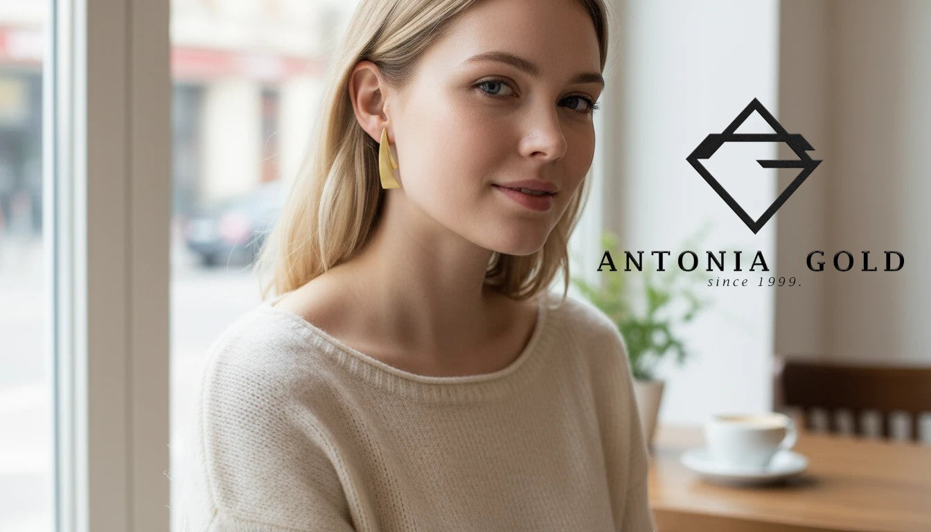 Femeie purtând cercei Antonia Gold geometrici din aur cu design triunghiular alungit și finisaj mat elegant