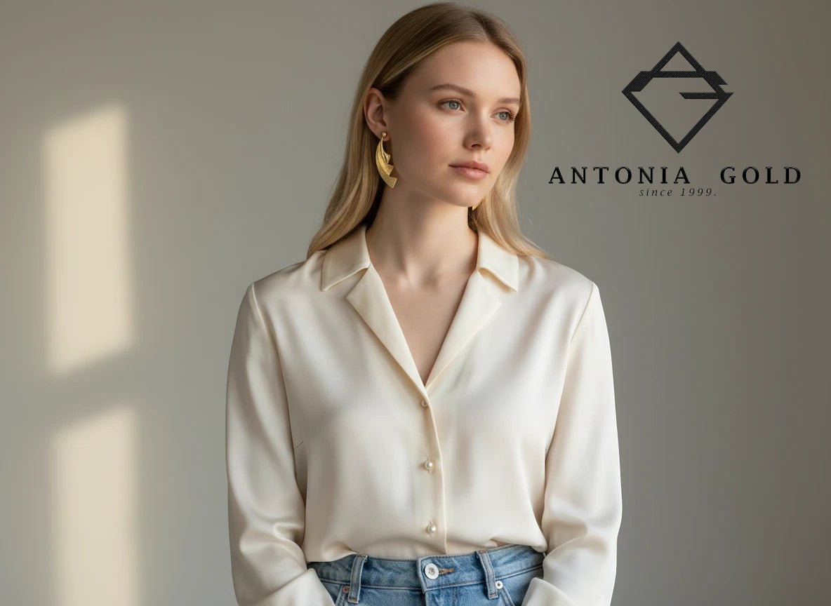 Cercei Antonia Gold din aur galben cu formă geometrică texturată purtați de o femeie cu cămașă albă din mătase