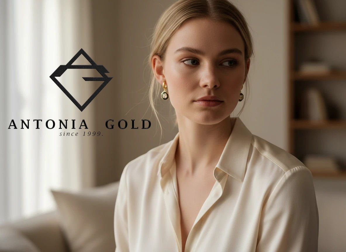 Cercei Antonia Gold octogonali din aur de 14K cu email negru și piatră prețioasă, purtați de o femeie elegantă.