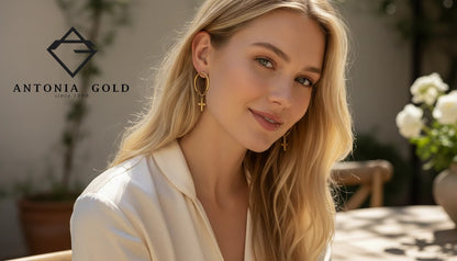 Cercei Antonia Gold tip cerc cu pandantiv cruciuliță placați cu aur purtați de o femeie cu păr blond