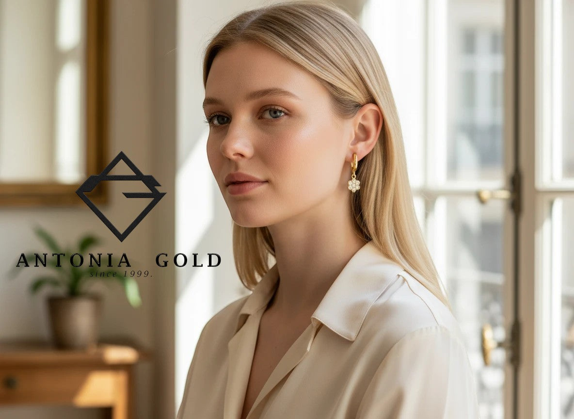 Cercei creole Antonia Gold din aur galben cu pandantiv floare și zirconii strălucitoare purtați de o femeie blondă
