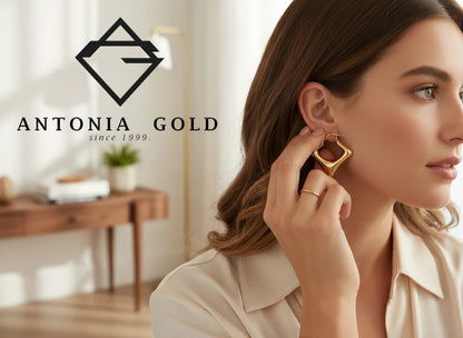 Cercei Antonia Gold tip creole pătrați din aur galben cu design geometric purtați de o femeie într-un cadru elegant