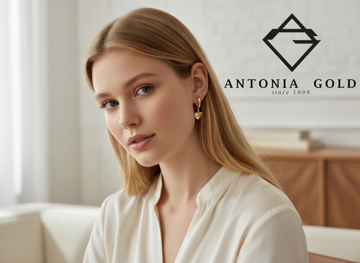Cercei Antonia Gold tip creole din aur galben cu pandantiv inimă și piatră strălucitoare purtați de o tânără blondă