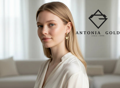 Femeie blondă purtând cercei creole din aur Antonia Gold cu pandantiv în formă de stea, design elegant și modern