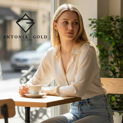 Femeie purtând cercei dreptunghiulari Antonia Gold din aur galben 14K, cu design minimalist și finisaj lucios.