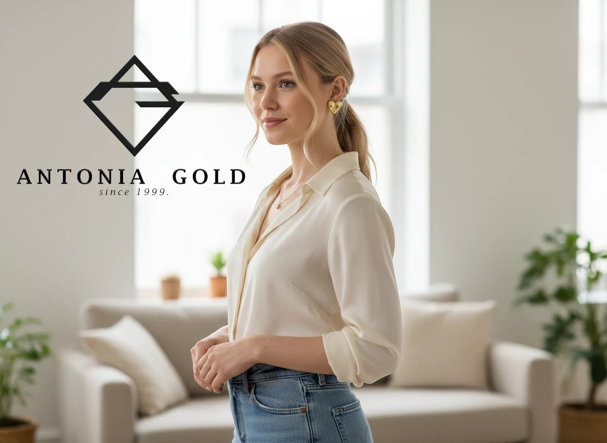 Femeie purtând cercei Antonia Gold în formă de inimă din aur galben, cu design minimalist și finisaj strălucitor.