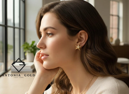 Cercei Antonia Gold tip stud în formă de stea de mare din aur galben cu diamant central, purtați de o femeie elegantă